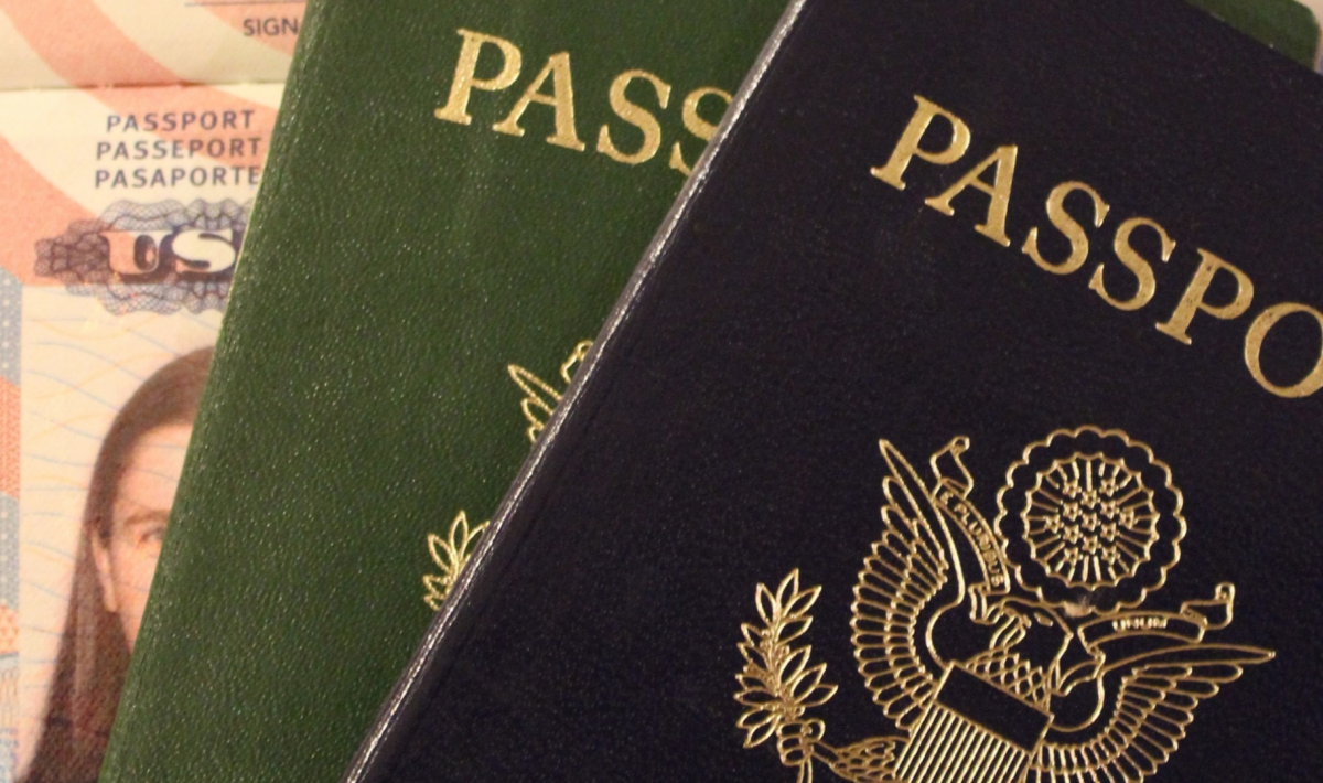 a green and blue passport on an American ID card